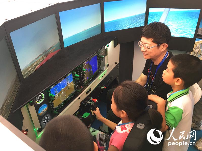 孩子們在飛行愛好者的指導下體驗飛行模擬機（高黎明/人民網）