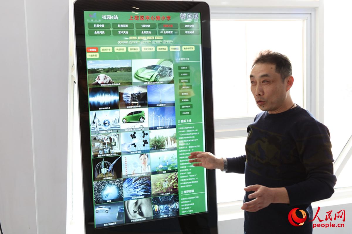 郑州市上街区中心小学老师在介绍科普中国“校园e站”展示屏。（崔钟文/人民网）